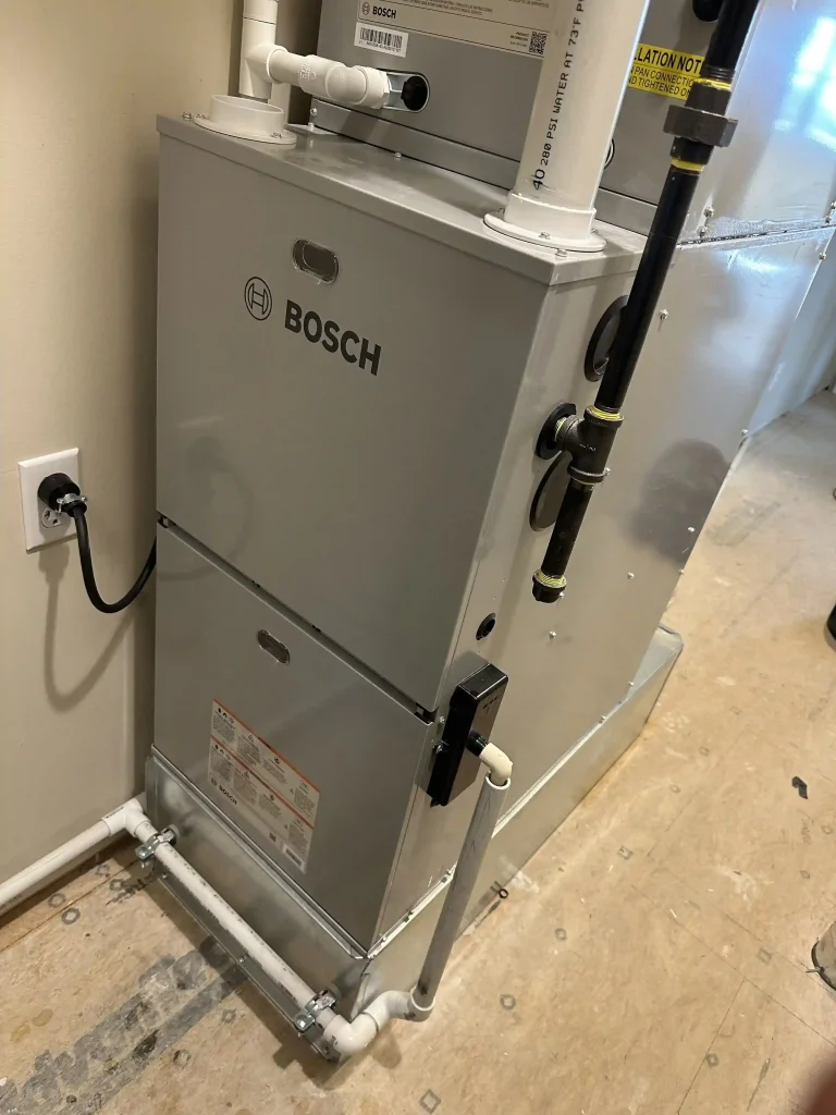 Bosch residential HVAC furnace with connected ductwork, ventilation pipes and gas piping