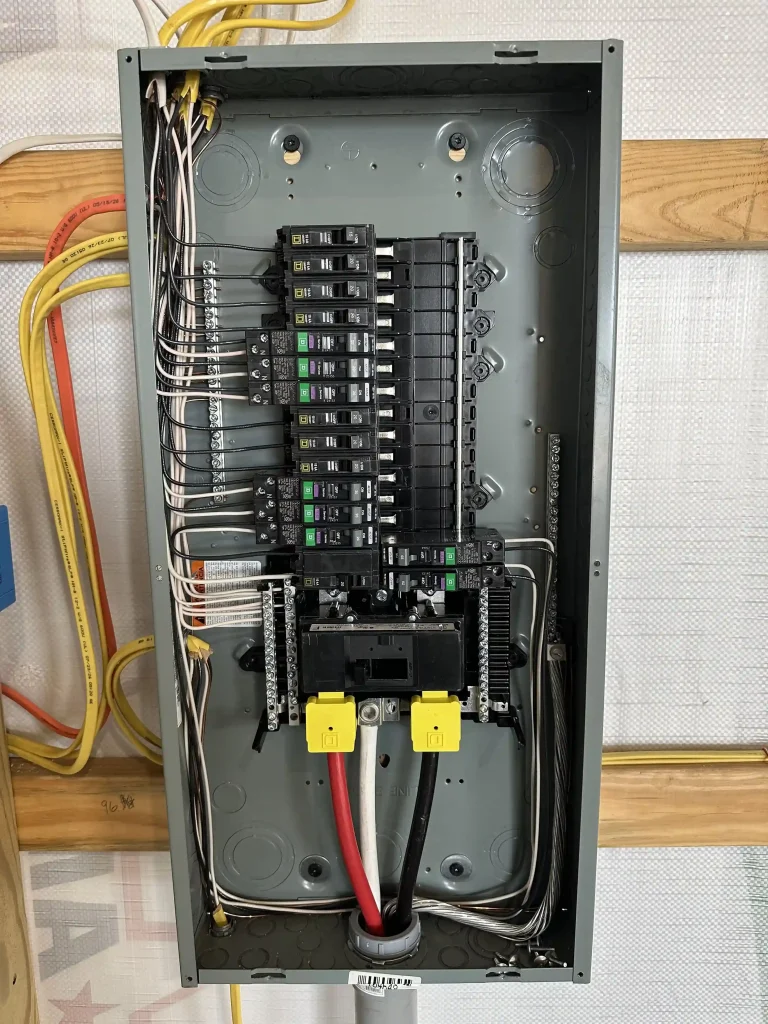 Open residential electrical panel showing circuit breakers, wiring and electrical connections
